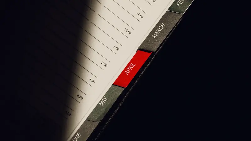 Agenda ouvert sur ses onglets mensuels, celui d'avril marqué en rouge