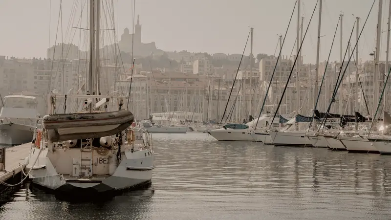 Voiliers amarrés au Vieux-Port de Marseille avec Notre-Dame de la Garde sur la colline