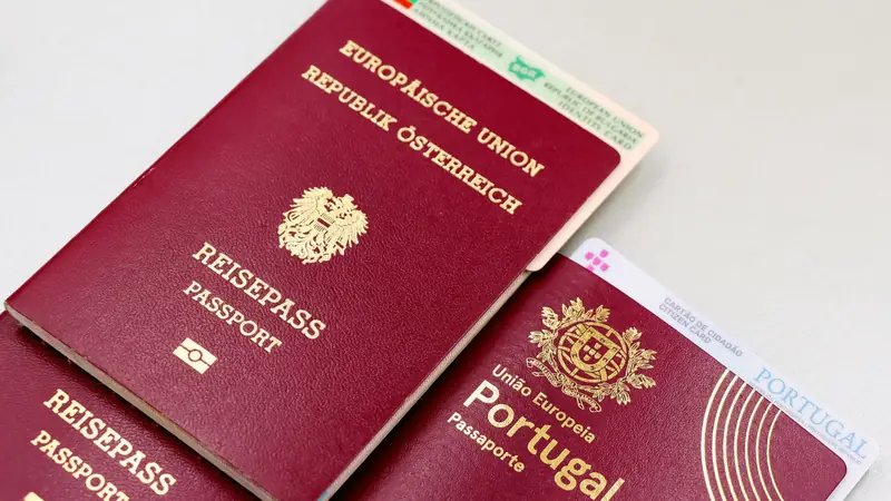 Passeports européens bordeaux d'Autriche et du Portugal posés avec des cartes d'identité