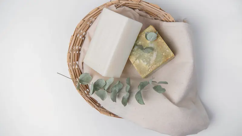 Panier en osier avec savons, linge et brin d'eucalyptus pour l'accueil des voyageurs
