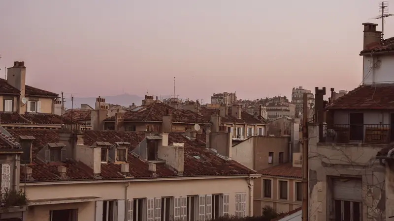 Toits de tuiles et façades d'immeubles marseillais au coucher du soleil